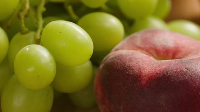 Grape green grapes with peaches and melon, fresh fruit assortment close-up macro shot