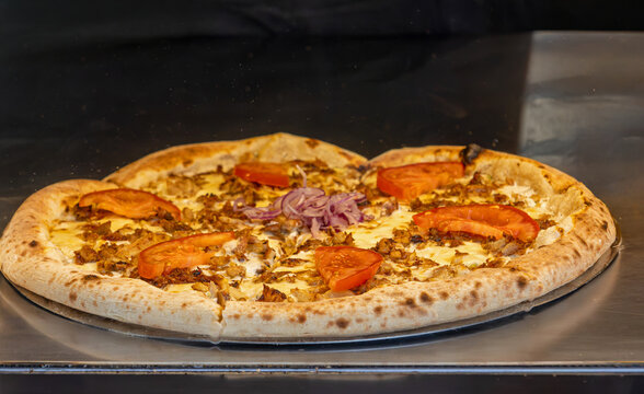 Tasty fresh baked pizza on plate on restaurant counter