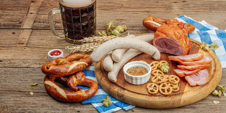 Traditional Oktoberfest set. Pretzels, beer, weisswurst, eisbein with mustard. German festival food