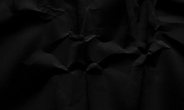 Dark black crumpled paper texture background with creased folds and dramatic shadows for creative design Background