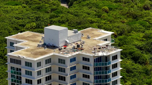 Aerial parallax video rooftop of a highrise surrounded by nature