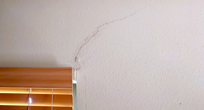 drywall (plasterboard, sheetrock) crack by bedroom window frame due to ground subsidence or movement