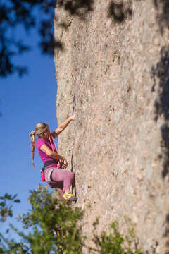 Young woman rock climbing on cliffs in montserrat