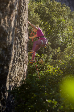 Young woman rock climbing a challenging mountain route