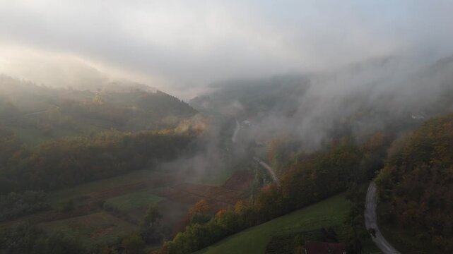 A drone camera flies over autumn mountains early in the morning at dawn