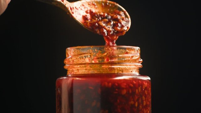 Chinese Crispy Chili Oil in Glass Jar, Homemade Chili Crisp with Garlic, Shallots and Sesame Seeds, Authentic Spicy Asian Condiment, Close Up Macro Video for Cafe and Restaurant Menu