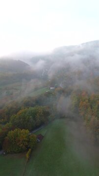 A drone camera flies over autumn mountains early in the morning at dawn. Vertical video