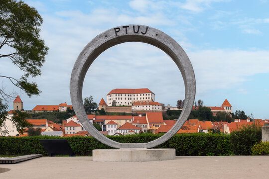 City Ptuj ring sculpture in Slovenia with its red-roofed buildings by the Drava River and the castle above the town.