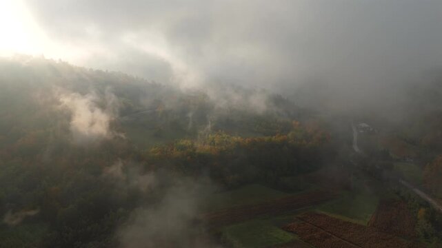 Aerial view of mountain forests shrouded in morning mist with dramatic sunbeams breaking through the clouds	