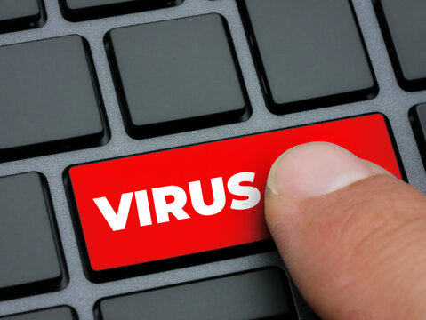 Close up finger pressing red virus key on computer keyboard