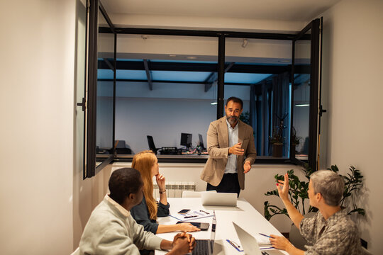 Manager leading team meeting in modern office