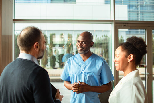 Healthcare professionals meeting with executive in hospital lobby