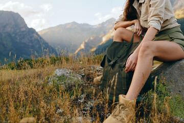 Naklejka premium Cheerful woman outdoors, enjoying mountain nature in a casual hiking scene, sitting on a rock, sunlit landscape, relaxed posture, warm colors and natural textures soft