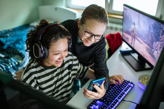 Teen friends gaming together on a pc at home