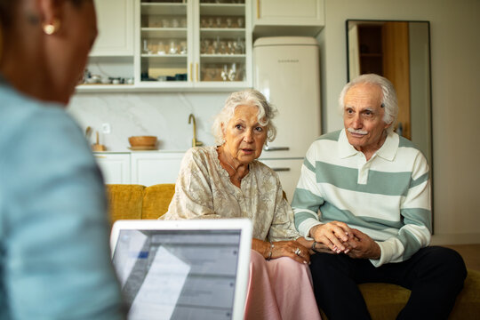Senior couple meeting advisor at home in living room