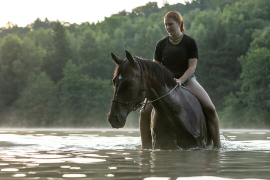 Reiterin badet mit Pferd