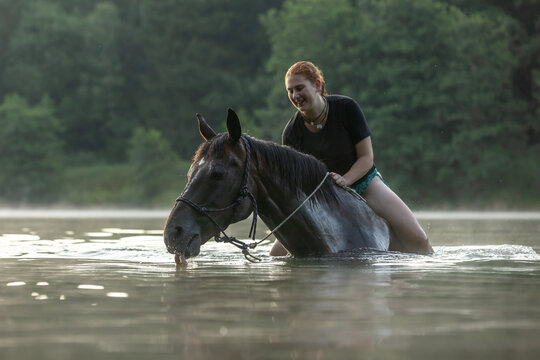 Reiterin badet mit Pferd