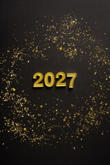 Fototapeta premium Happy New Year 2027 coming celebration with gold confetti on black winter holiday vertical background