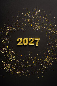 Happy New Year 2027 coming celebration with gold confetti on black winter holiday vertical background