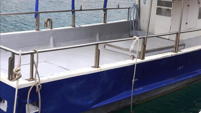A boat is at the pier with ropes securing it