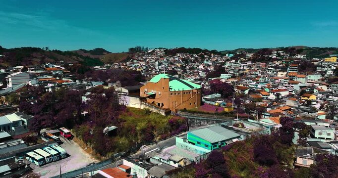 4K aerial drone view of a historic Catholic church surrounded by traditional houses and urban architecture in Santa Isabel, S&atilde;o Paulo, Brazil.