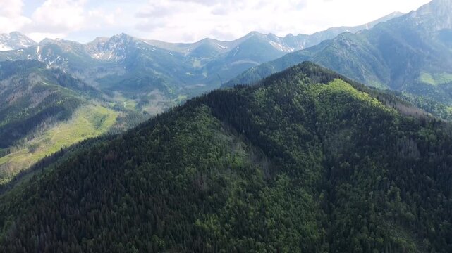 Drone aerial view of Gubał&oacute;wka in Zakopane, Poland, overlooking lush green landscapes and the majestic Tatra Mountains. Horizontal footage showcasing breathtaking Polish nature, travel and tourism