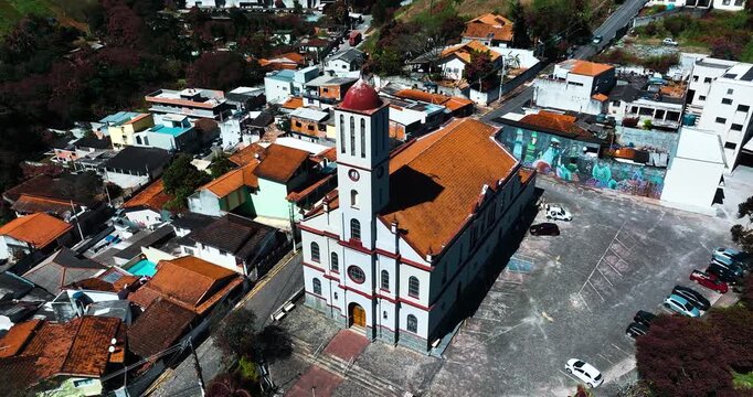 4K aerial drone view of a historic Catholic church surrounded by traditional houses and urban architecture in Santa Isabel, S&atilde;o Paulo, Brazil.