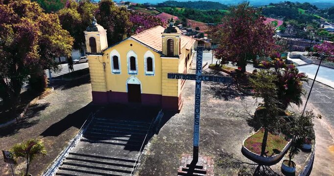 4K aerial drone view of a historic Catholic church surrounded by traditional houses and urban architecture in Santa Isabel, S&atilde;o Paulo, Brazil.