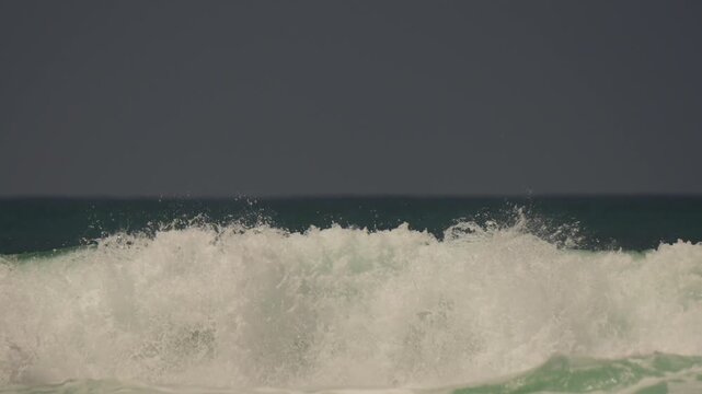 Close up of waves breaking to shore on the beach