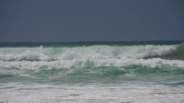 Large waves breaking on the beach in the summer