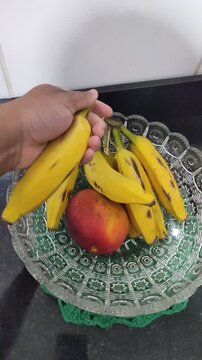 pegando uma banana na fruteira da cozinha, alimenta&ccedil;&atilde;o saud&aacute;vel 