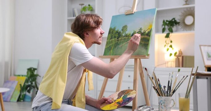 Man painting on canvas indoors. Artist working in studio