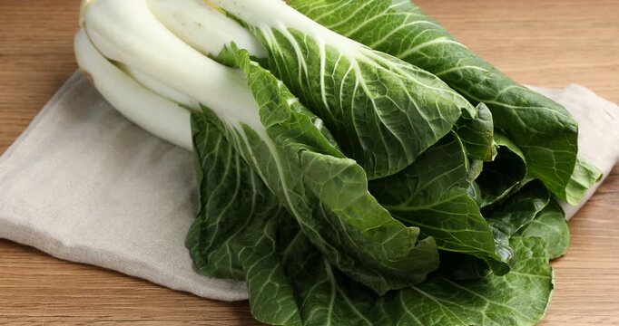 Ripe bok choi (Chinese cabbage) on wooden table, zooming in