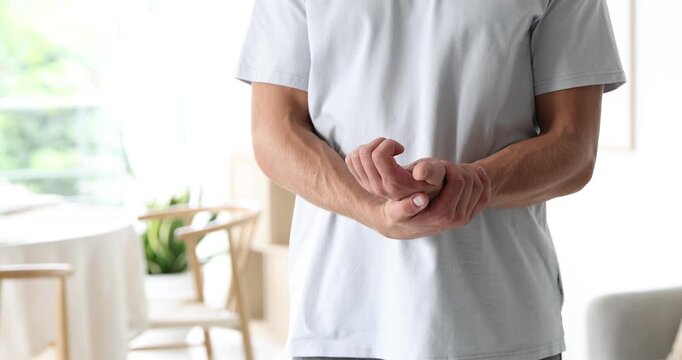 Man checking his pulse with fingers indoors, closeup
