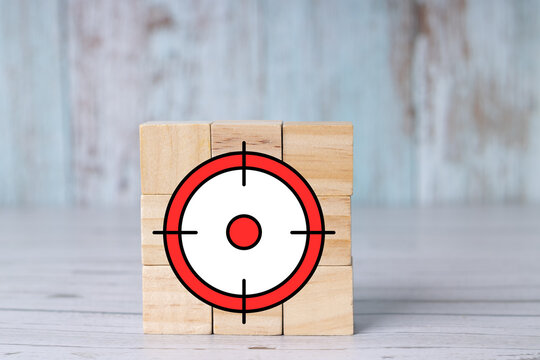 Precision scope reticle and target on wooden blocks; concept of focus and objectives featuring a bullseye symbol.