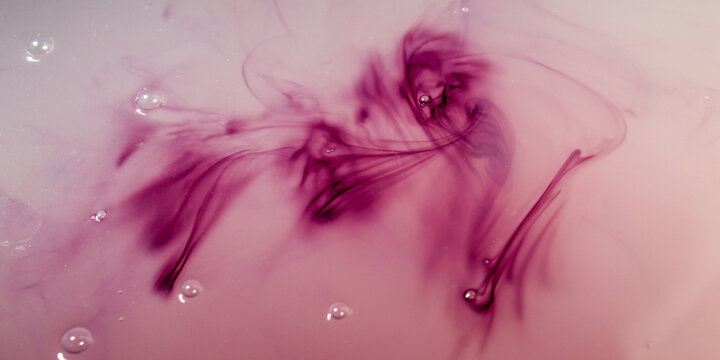 a dark purple liquid that slowly dissolves, spreads, and swirls in a cloudy white liquid medium