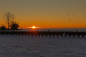 Obraz premium Winter sunrise over a frozen pier and Lake Erie at Port Dover, Ontario, Canada.