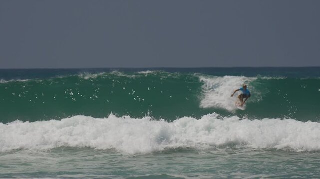 surfer riding large wave in huntington beach CA