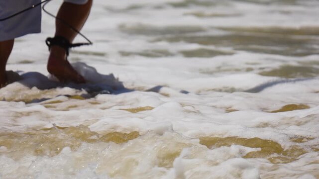 Surfer walking out to the ocean in shallow water