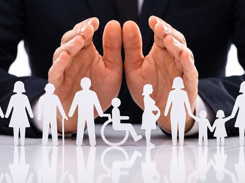 Businessman hands protecting paper cutouts representing inclusive social security insurance and corporate safety support services