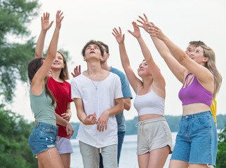 Obraz premium A group of student friends spend time actively relaxing on the riverbank.