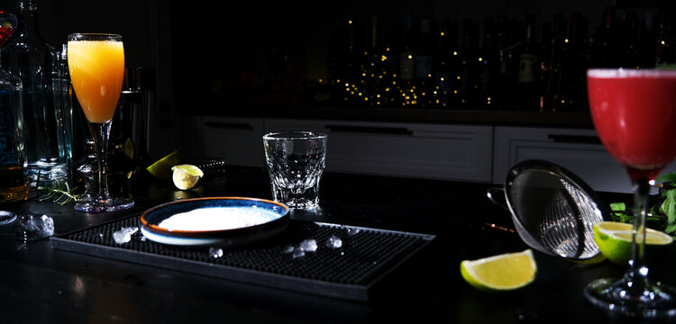 Empty shot glass near salt plate waiting for cocktail preparation. Setup for craft tequila drinks.
