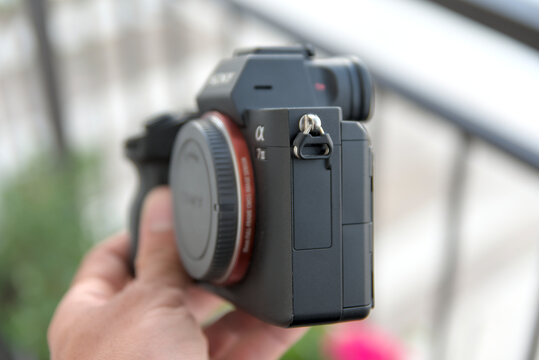ZAPOPAN, MEXICO - AUGUST 19, 2026: Hand holding side view of Sony Alpha 7 III camera body.