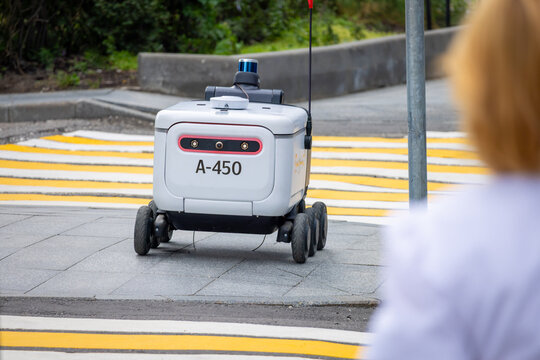 Yandex delivery robot on a city street. A small six-wheeled autonomous rover delivers or carries goods. Moscow, Russia - July 20, 2024