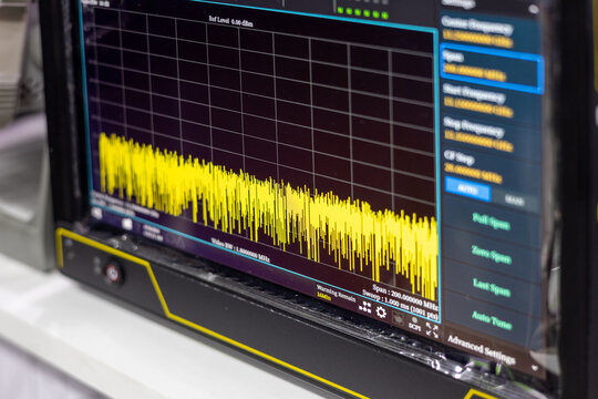Modern digital oscilloscope screen displaying high frequency signal waveforms in a professional laboratory. Electronic measurement and diagnostic equipment for engineering research