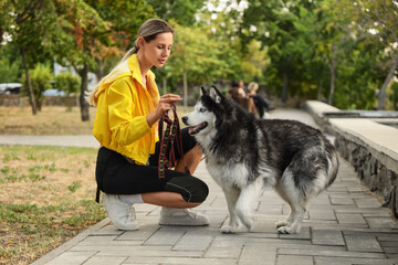 Pet ownership and animal companionship, young woman with husky dog on a leash in a park, outdoor activity and healthy lifestyle © Pixel-Shot