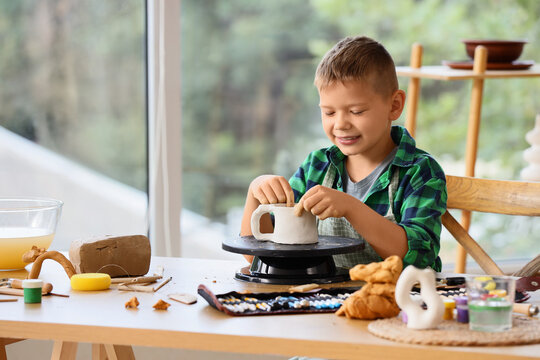 Child development and creative learning, young boy making pottery with clay at home, art therapy and childhood education