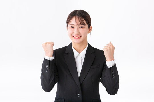 ガッツポーズをするスーツの若い女性