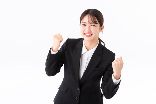 ガッツポーズをするスーツの若い女性