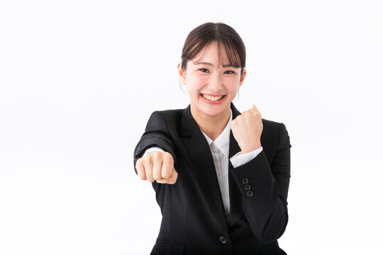 ガッツポーズをするスーツの若い女性